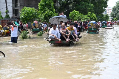 People commute on a rickshaw van in waist-deep water in Dhaka on Friday, September 22, 2023. Mahmud Hossain Opu/Dhaka Tribune