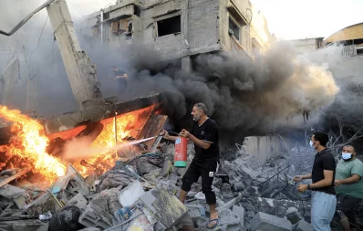 A Palestinian man uses a fire extinguisher to douse a fire following an Israeli strike, in Khan Yunis in the southern Gaza Strip on October 14, 2023, as fighting between Israel and the Hamas movement continues for the eighth consecutive day. Photo: AFP