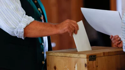 A voter wearing a traditional Bavarian costume casts his ballot for the European Parliament Elections at a polling station in Huglfing, southern Germany, on June 9, 2024. Photo: AFP