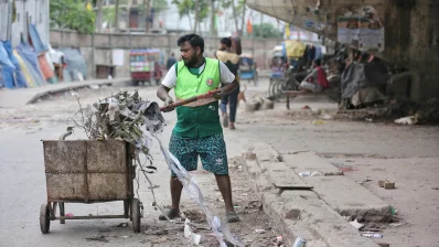 A city corporation worker is seen cleaning animal waste in Dhaka on Monday, June 17, 2024. Photo: Ahadul Karim Khan/Dhaka Tribune