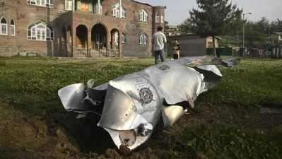 People stand near a part of an aircraft in Wuyan near Indian-administered Kashmir`s main city of Srinagar on May 7, 2025. Photo: AFP