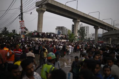 Fire service personnel working at the site to rescue people as crowds gather outside following the F-7 training jet crash at Milestone School and College. Photo: Mahmud Hossain Opu/Dhaka Tribune