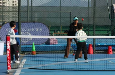 Safina guiding young tennis players during a training session