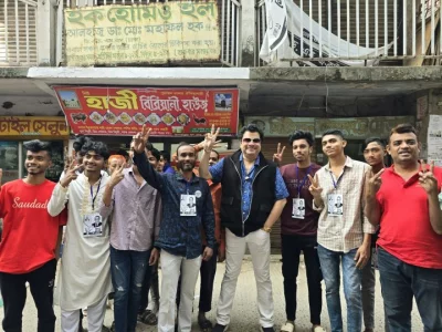Rabi Chowdhury poses with fans at a polling centre during the national election