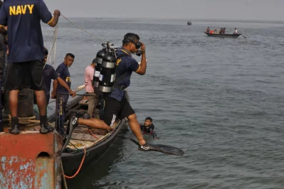 Onlookers gather at the shoreline while divers conduct rescue and recovery efforts at Daulatdia ghat on Thursday. A Dhaka-bound bus plunged into the Padma River while attempting to board a ferry at the terminal leaving dozens dead, on Wednesday, March 25, 2026.