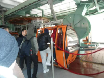 The Mutianyu Great Wall Cable Car station in Beijing, China. These distinctive orange, fully enclosed gondolas are a primary way for visitors to access the Mutianyu section of the Great Wall.