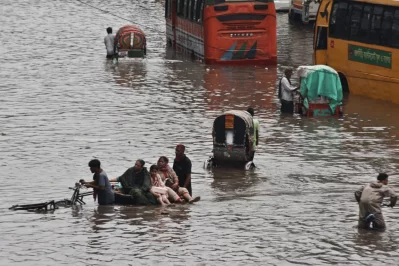 People and vehicles make their way through waterlogged streets in the Arambagh area after heavy monsoon rain inundated parts of Dhaka on Sunday, disrupting traffic and causing hardship for commuters. Photo: Ahadul Karim Khan/Dhaka Tribune