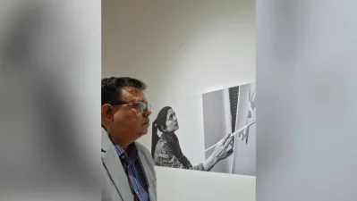 The writer looking at a display panel at an exhibition on Novera Ahmed’s works at Bangladesh National Museum. The historical black-and-white archival photograph in the background depicts Novera Ahmed herself at work, painting on a large canvas. Photo: Collected/Dhaka Tribune