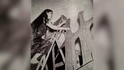 The image shows Novera balanced on a wooden ladder, actively modeling and refining a large-scale, texture-heavy plaster or concrete structure. This piece belongs to her prolific late 1950s period in Dhaka, where she worked long hours in her studio to prepare for her historic first solo exhibition in 1960. Photo: Collected/Dhaka Tribune