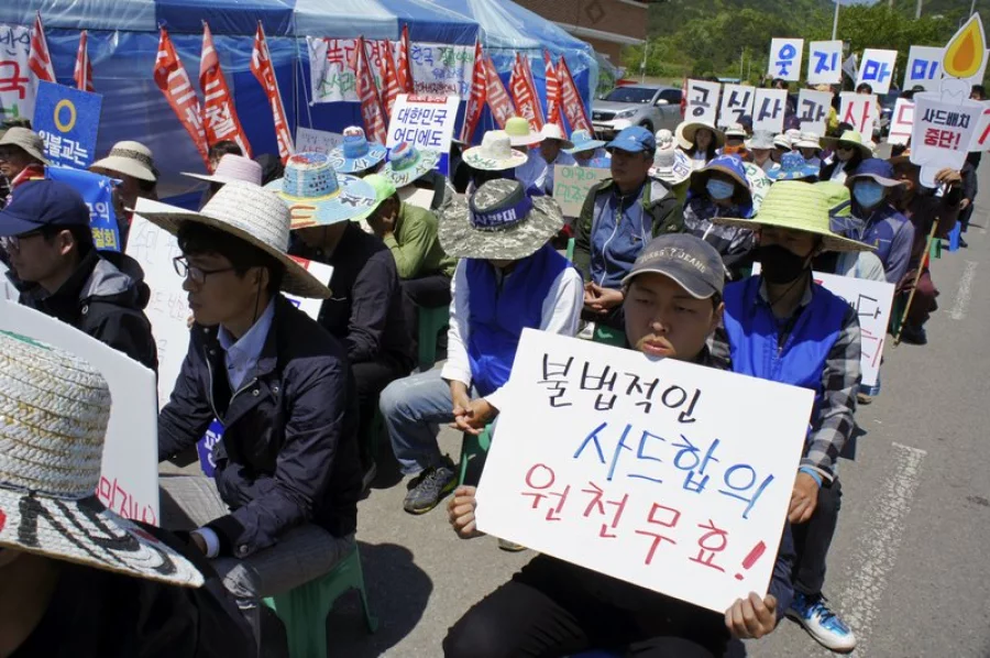 In this April 28, 2017 photo, South Korean residents attend a rally to oppose a plan to deploy an advanced U.S. missile defense system called Terminal High-Altitude Area Defense, or THAAD, near the system's site in Seongju, South Korea. The letters read on the banner "Nullify Illegal THAAD Agreement." Clashes between residents and police over the deployment of an advanced U.S. anti-missile system highlight a divisive issue ahead of South Korea’s presidential election on May 9. (AP Photo/Kim Tong-hyung)