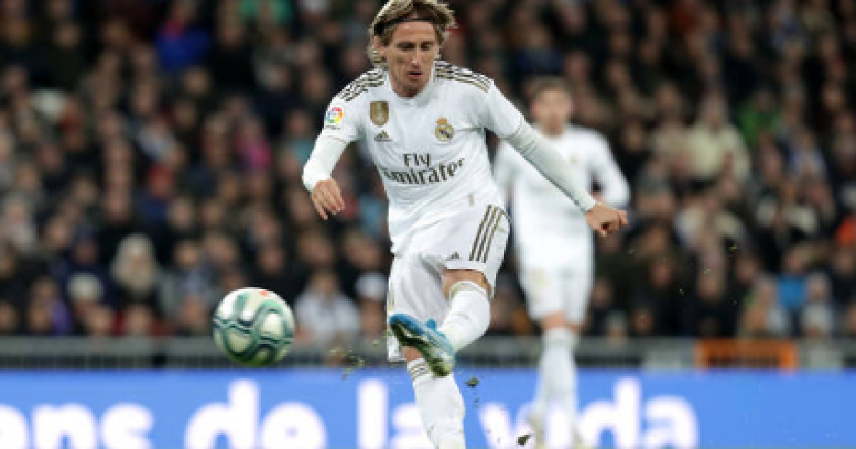 Luka Modric poses with his Real Madrid shirt and his Barcelona shirt