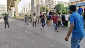 Anti-quota protesters play football on empty Dhaka road