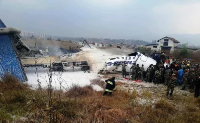 This picture obtained from the Twitter account of Saroj Basnet shows Nepali rescue workers gathering around the debris of an airplane that crashed near the international airport in Kathmandu on March 12, 2018rnAFP