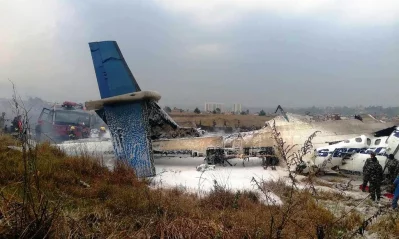 This picture obtained from the Twitter account of Saroj Basnet shows Nepali rescue workers gathering around the debris of an airplane that crashed near the international airport in Kathmandu on March 12, 2018rnAFP