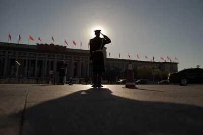 A paramilitary police officer saluts at a security check point as a car with officials drive past ahead of the CPPCC Closing ceremony at the Great Hall of the People in Beijing on March 13, 2017. More than 3000 delegates from across China are attending the annual meeting of the countrys rubber-stamp congressrnrnAFP