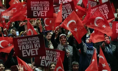 People hold banners and wave Turkish flags during a meeting of  Turkish President as part of the campaign for the constitutional referendum in Ankara, on March 29, 2017rnrnAFP