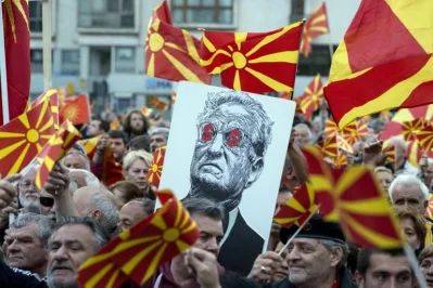 People hold a placard dipicting billionaire George Soros during a demonstration against a deal between Social Democrats and the Albanian Democratic Union for Integration, about a law making Albanian the second official language, on March 30, 2017 in SkopjernrnAFP