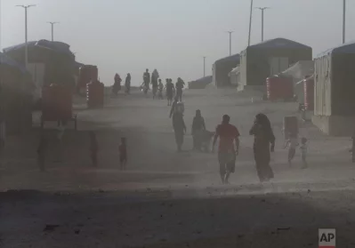 Syrian displaced people who fled the battle between US-backed Syrian Democratic Forces and the Islamic State militants from Raqqa city, walk in the dust at a refugee camp, in Ain Issa town, northeast Syria, Wednesday, July 19, 2017.  The US military is supporting local Syrian forces in a campaign to drive IS from RaqqarnAP