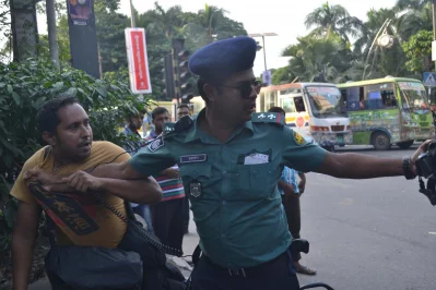 DMP Traffic Sergeant Md Mustain snatches away Daily Manab Zamin photojournalist Nasir Uddins camera and grabs him by the shirt, trying to drag him to the police box in Ramna, Dhaka on October 11, 2017 || Dhaka Tribune