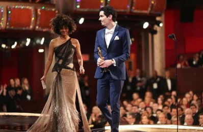 Director Damien Chazelle (R) accepts Best Director for La La Land from presenter Halle Berry onstage during the 89th Annual Academy Awards at Hollywood &amp; Highland Centre on February 26, 2017 in Hollywood, California/AFP