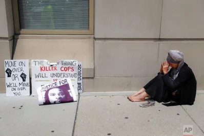 A protester prays outside the offices of Hamilton County Prosecutor Joseph Deters following a news conference Tuesday, July 18, 2017, where Deters announced his decision to not pursue a third trial of former University of Cincinnati police officer Ray Tensing on murder charges for the death of motorist Sam DuBose, in CincinnatirnrnAP