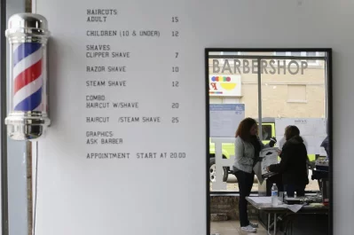 A voter hands over her ballot to an elections worker at a barber shop used as a polling station in Chicago. Photo: Jim Young