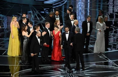 La La Land producer Jordan Horowitz (lower left) stops the show to announce the actual Best Picture winner as Moonlight following a presentation error onstage during the 89th Annual Academy Awards at Hollywood &amp; Highland Centre on February 26, 2017 in Hollywood, California/AFP