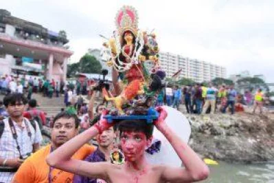 A child carries a miniature Durga idol for immersion. Photo: Dhaka Tribune/Mahmud Hossain Opu