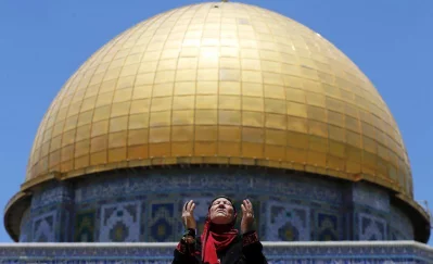A Palestinian woman prays in front of the Dome of the Rock on the first Friday of the holy month of Ramadan at the compound known to Muslims as the Noble Sanctuary and to Jews as Temple Mount, in Jerusalems Old City June 19, 2015 (REUTERS)