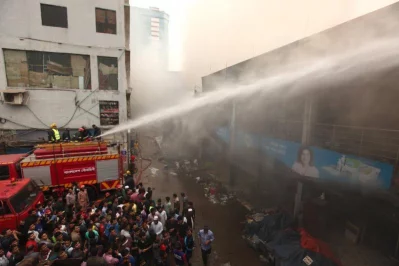Firefighters seen trying to douse the fire as bystanders look on RAJIB DHAR/DHAKA TRIBUNE