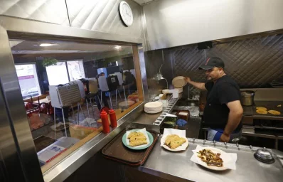 A cook prepares food orders in a kitchen as voters cast their ballots at a restaurant used as a polling station in Chicago. Photo: Jim Young