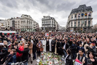 People stand for a moment of silence at the Bourse during the one-year anniversary for Brussels attacks victims in Brussels on Wednesday, March 22, 2017. Belgian leaders, victims and families of those who died in the suicide bomb attacks on the Brussels airport and subway are marking the first anniversary of the attacks, which killed 32 people and wounded more than 300 othersrnrnAP