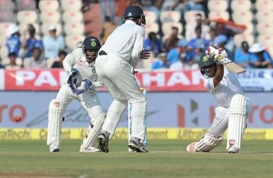 Bangladeshs Mehedi Hasan plays a shot as Indias wicketkeeper Wriddhiman Saha watches on the third day of the only Test match between India and Bangladesh at the Rajiv Gandhi International Cricket Stadium in Hyderabad on February 11, 2017/AFP PHOTO