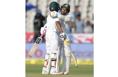 Bangladeshs captain Mushfiqur Rahim congratulates Mehedi Hasan on the third day of the only Test match between India and Bangladesh at the Rajiv Gandhi International Cricket Stadium in Hyderabad on February 11, 2017/AFP PHOTO