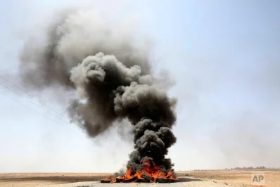 A pile of tires is seen burning on a road leading to the southern Jordanian town of al-Jafr on Tuesday, July 18, 2017. Hundreds of people in al-Jafr staged protests Tuesday following the conviction of a local soldier a day earlier in the shooting deaths of three US military trainers. The US troops were killed in November at the gate to the al-Jafr air base when their convoy came under fire  AP