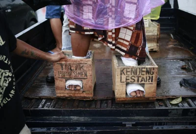 In this March 19, 2017 photo, villagers from Kendeng, Central Java who has their feet encased in concrete in protest against the operation of a cement factory near their villages, rest at their temporary shelter at the Legal Aid Institute office in Jakarta, Indonesia. Dozens of farmers and activists opposed to the factory have encased their feet in concrete during a days-long protest in Jakarta, the capital. Farmers in the village of Kendeng have battled against plans for the factory for years, saying it could taint their waterrnrnAP