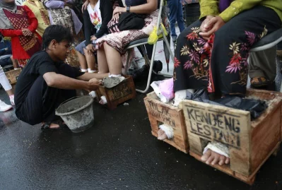 In this March 20, 2017 photo, activists have their feet encased in concrete during a rally outside the presidential palace in Jakarta, IndonesiarnrnAP
