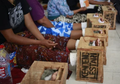 In this March 19, 2017 photo, women protesting against the operation of a cement factory in Kendeng, Central Java, whose feet are encased in concrete rest at their temporary shelter at the Legal Aid Institute office in Jakarta, IndonesiarnrnAP