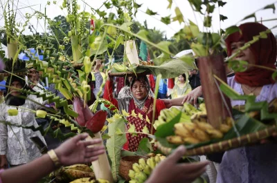 In this March 20, 2017 photo, protesters from Kendeng, Central Java, carry traditional Javanese offerings during a rally against the operation of a cement factory near their villages, outside the presidential palace in Jakarta, IndonesiarnrnAP