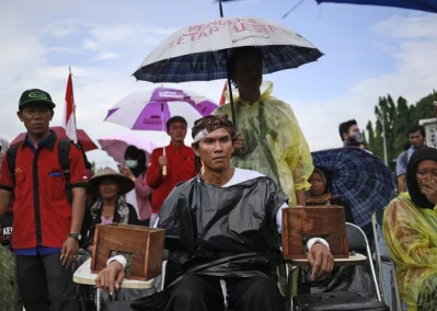 In this March 20, 2017 photo, a protester has his arms encased in concrete during a rally against the operation of a cement factory in Kendeng, Central Java, outside the presidential palace in Jakarta, IndonesiarnrnAP