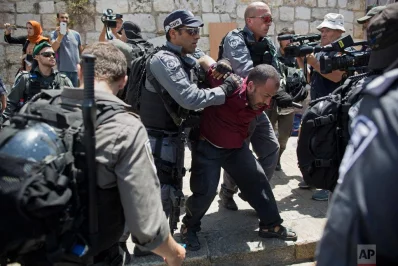 Israeli police officers detain a Palestinian man outside the Lions Gate, following an appeal from clerics to pray in the streets instead of the Al Aqsa Mosque compound, in Jerusalems Old City, Wednesday, July 19, 2017. A dispute over metal detectors has escalated into a new showdown between Israel and the Muslim world over the contested Jerusalem shrine that has been at the center of violent confrontations in the pastrnrnAP