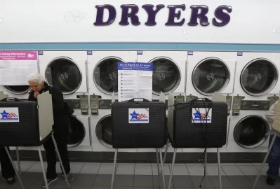 A voter looks over her ballot at a laundromat used as a polling station. Photo: Jim Young