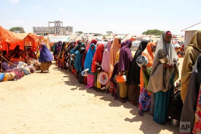 Displaced Somali women stand in a queue to receive food handouts in a camp, just outside of Mogadishu, in Somalia, Monday, March, 27, 2017. ufeffSomalias drought is threatening 3 million lives, according to the UN In recent months, aid agencies have been scaling up their efforts but they say said more support is urgently needed to prevent the crisis from worseningrnrnAP