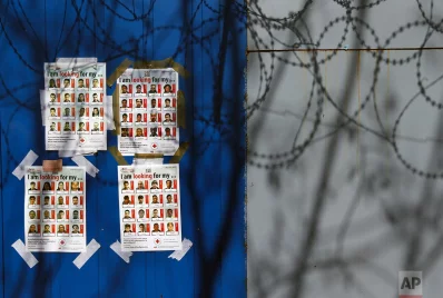 Posters with pictures of missing migrants are attached to a container at Serbias border with Hungary near a makeshift camp for migrants in Horgos, Serbia, Tuesday, March 28, 2017. Hungarys new legislation allowing for the placement of all asylum-seekers in border container camps took effect Tuesday, with the European Unions commissioner for migration saying that it needs to comply with the blocs rulesrnrnAP