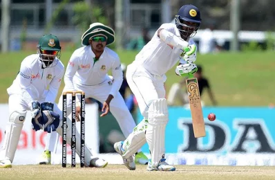 Sri Lankan cricketer Upul Tharanga (R) is watched by Bangladesh wicketkeeper Liton Das (L) as he plays a shot during the fourth day of the opening Test match between Sri Lanka and Bangladesh in Galle on March 10, 2017/AFP PHOTO
