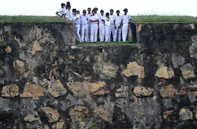 Sri Lankan schoolchildren on top of a 14th century Dutch fort near the Galle International Cricket Stadium watch the fourth day of the opening Test match between Sri Lanka and Bangladesh in Galle on March 10, 2017/AFP PHOTOrn