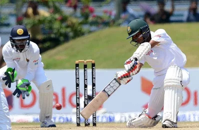 Bangladesh cricketer Mehedi Hasan (R) plays a shot as Sri Lanka wicketkeeper Niroshan Dickwella looks on during the third day of the opening Test cricket match between Sri Lanka and Bangladesh in Galle on March 9, 2017/AFP PHOTOrn