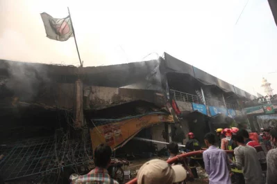 Bystanders look at the destruction in the wake of DNCC market fire RAJIB DHAR/DHAKA TRIBUNE