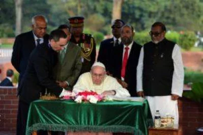 Pope Francis signs the visitors book at the National Memorial at Savar after paying tributes to the 1971 martyrs | Dhaka Tribune