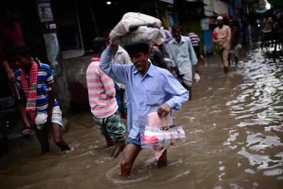 With knee high water in some areas, many resorted to using plastic bags and carrying their possessions over their head in an attempt to them dry, such as this commuter in Jurain | Mahmud Hossain Opu/Dhaka Tribune